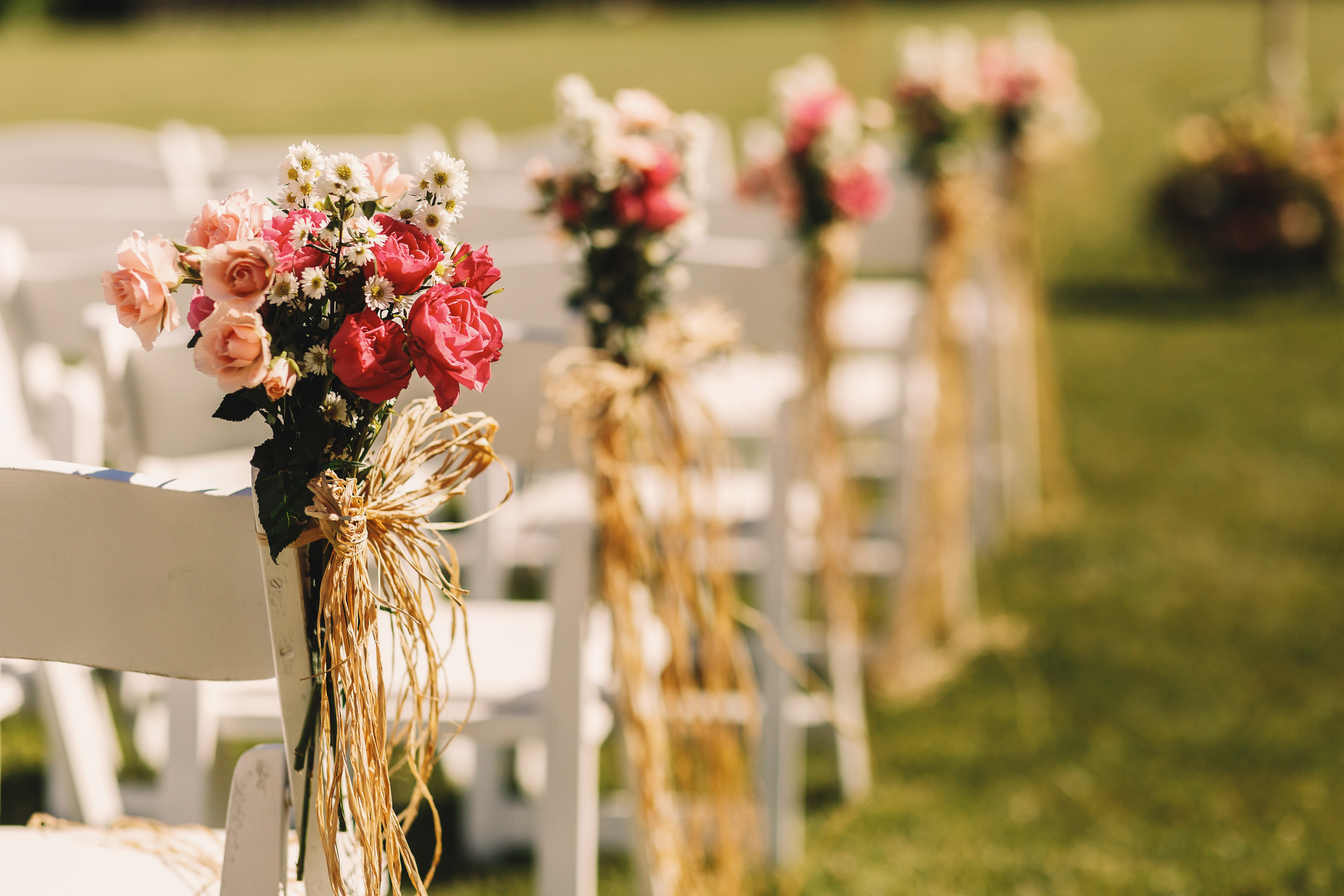 Bows of rope twine pink bouquets to white chairs Bows of rope twine pink bouquets to white chairs